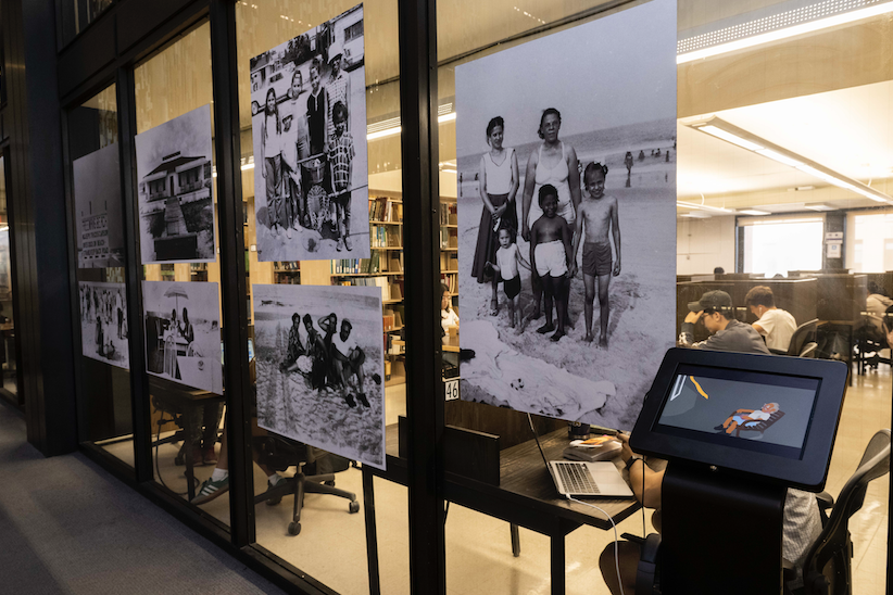 Pictures hung on a glass wall.