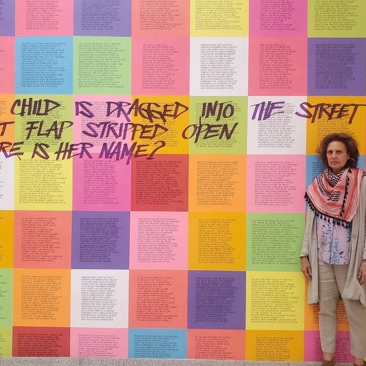 kathy stands in front of multicolor installation