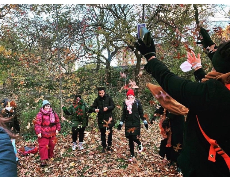 students throwing leaves on Seneca Village field trip