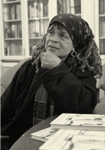 Sister Sonia Sanchez black and white photo in headwrap in the library 