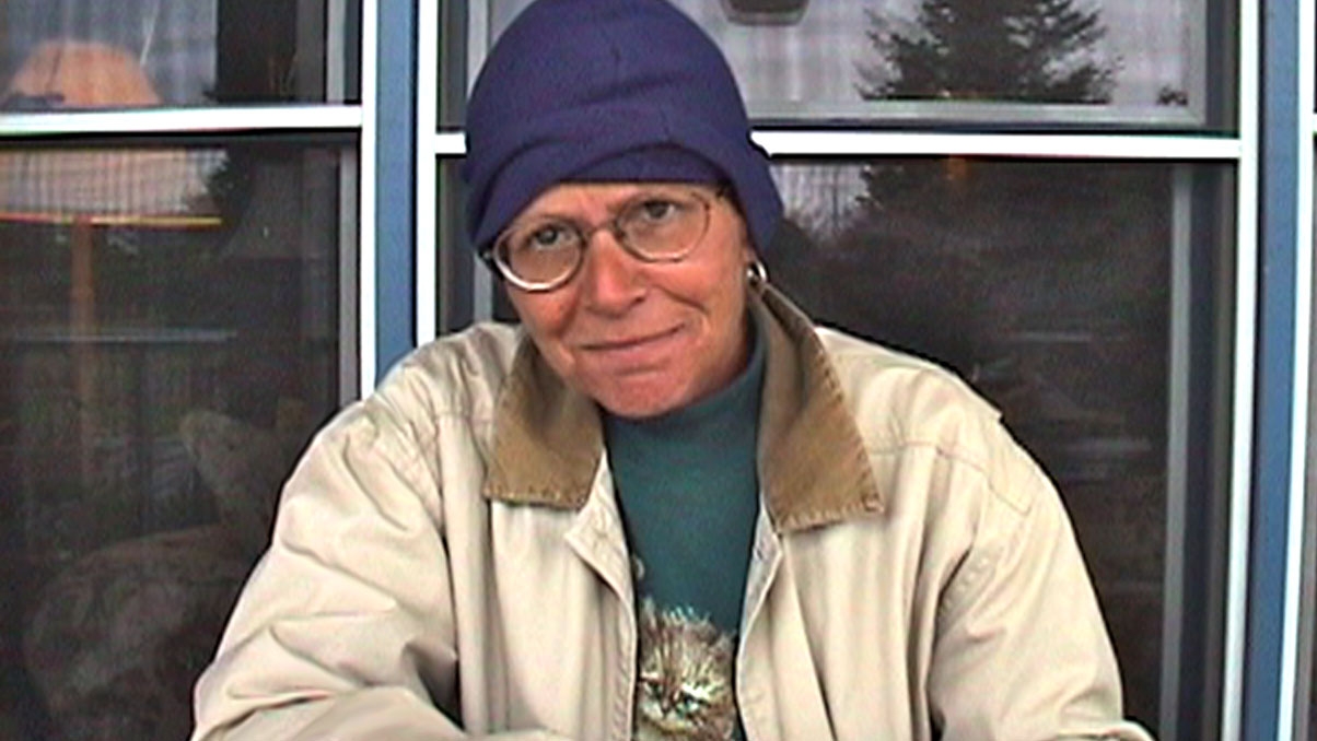 A woman sitting at a table looking straight into the camera