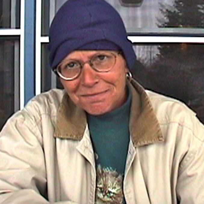 A woman sitting at a table looking straight into the camera