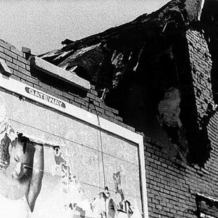 A billboard on the side of a deteriorating building.