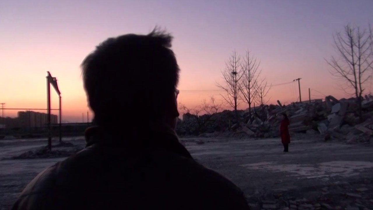 Man's head from behind looking out in the distance. The sky is pink.