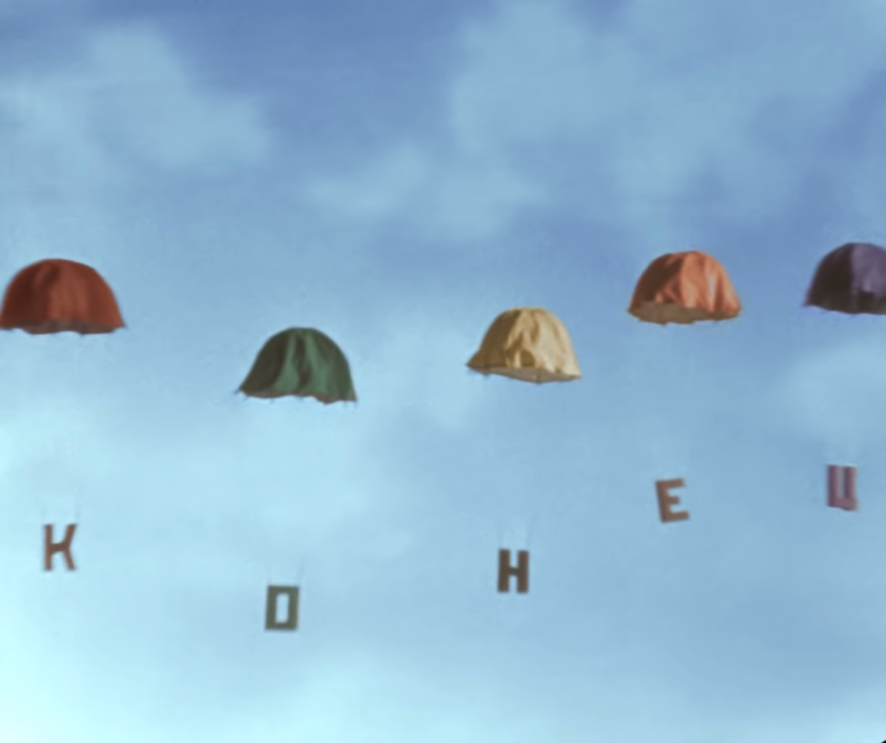 Parachute balloons with cyrillic letters hanging from them that says 