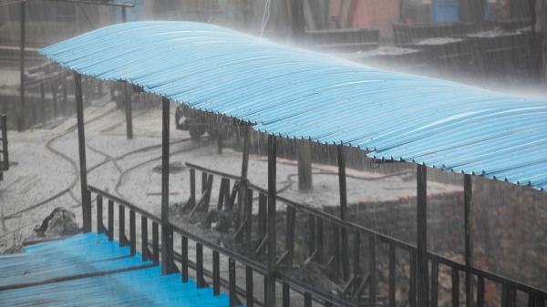 A wooden covered bridge with a bright blue roof