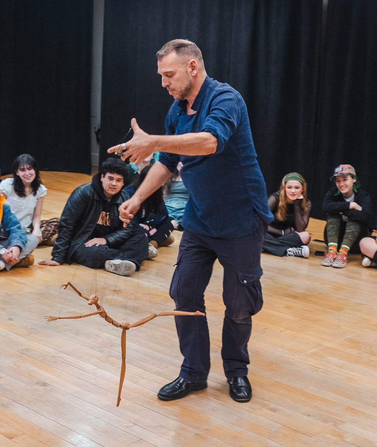 Basil Twist demonstrate a marionette puppet to students