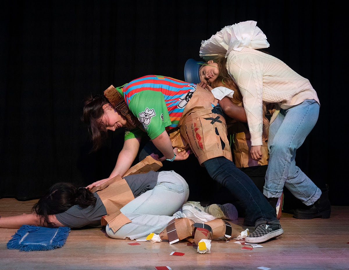 Students in colorful costumes are slumped over each other