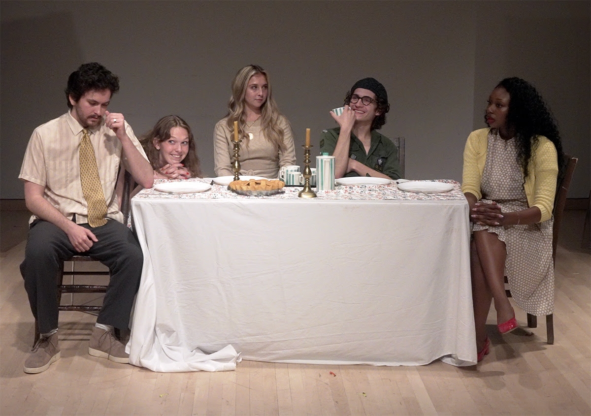 Rory and 4 other performers sit around a dinner table