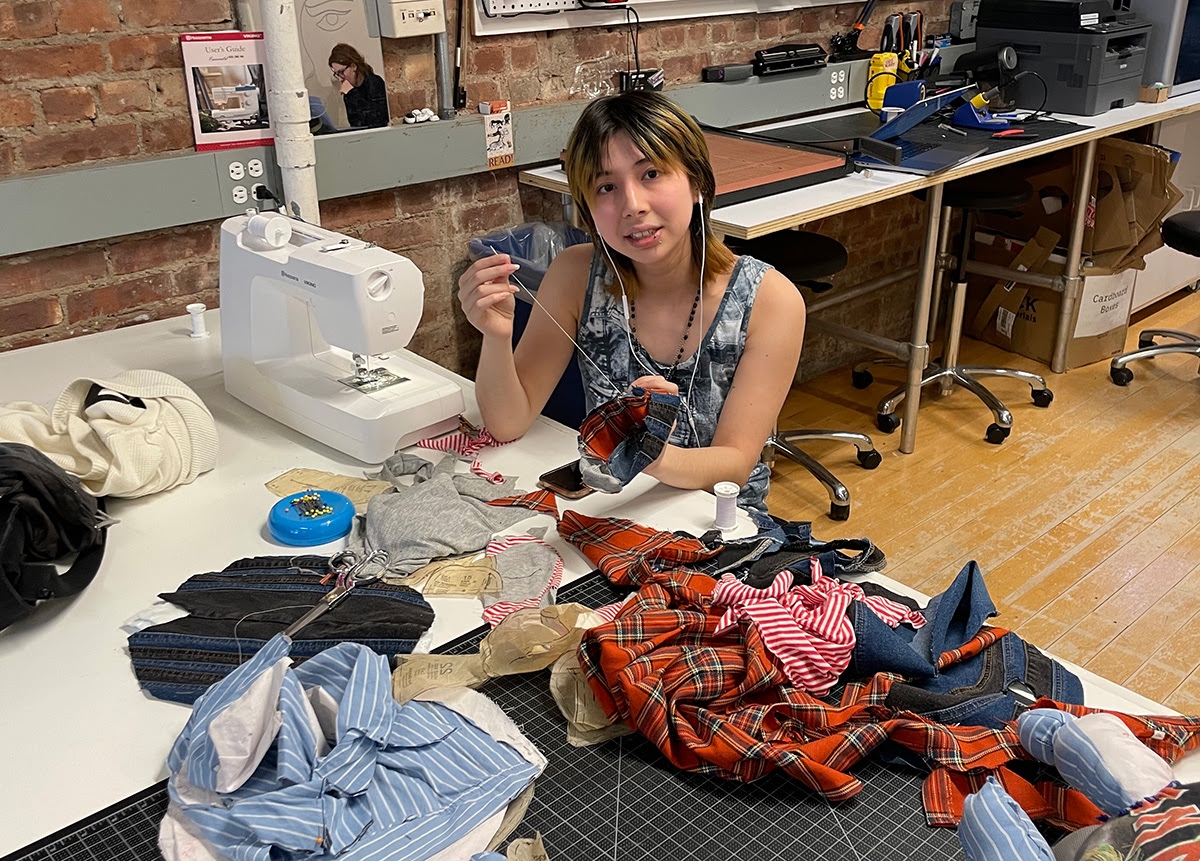 Student works with various fabrics at sewing machine