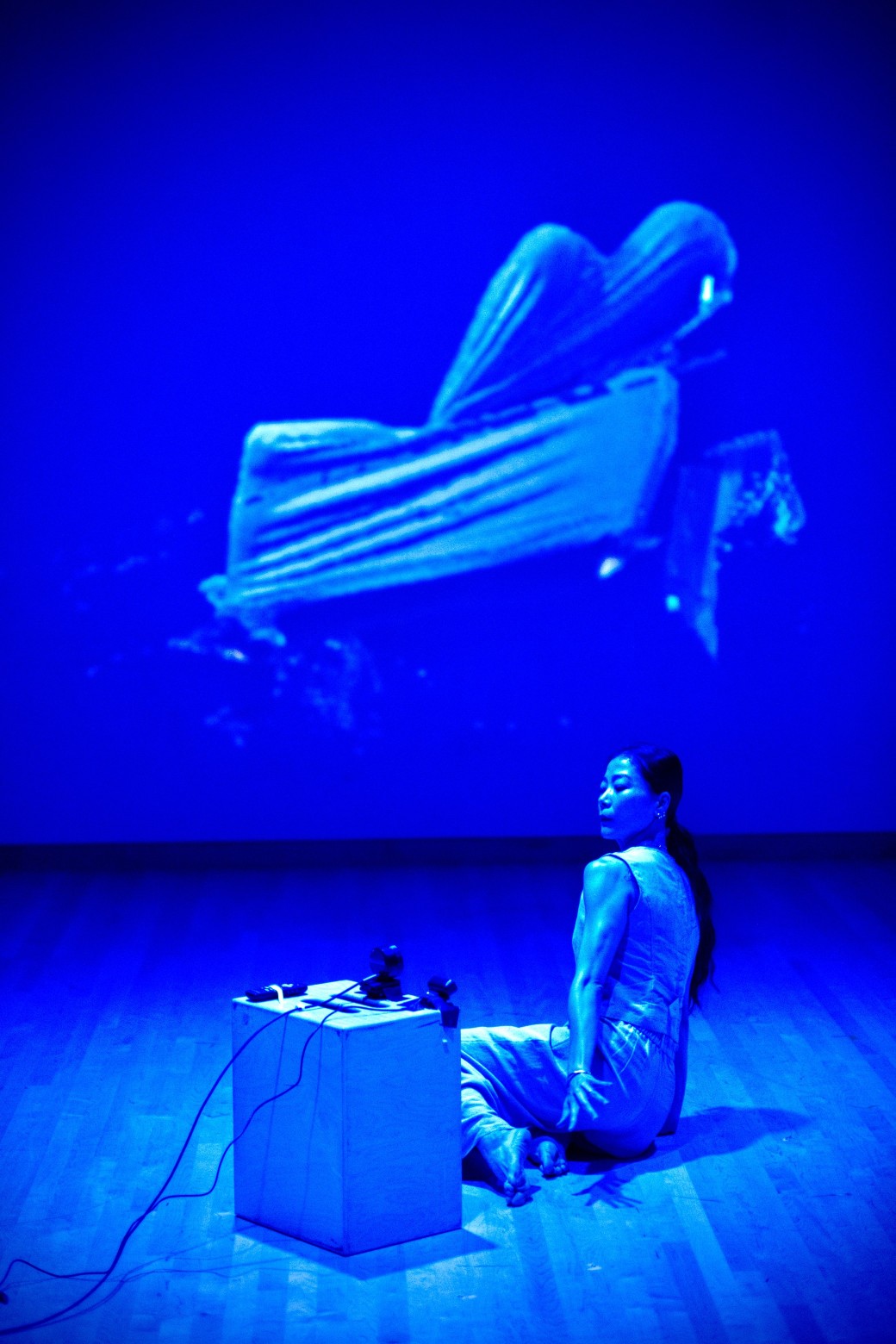 Performance artist on stage with blue light