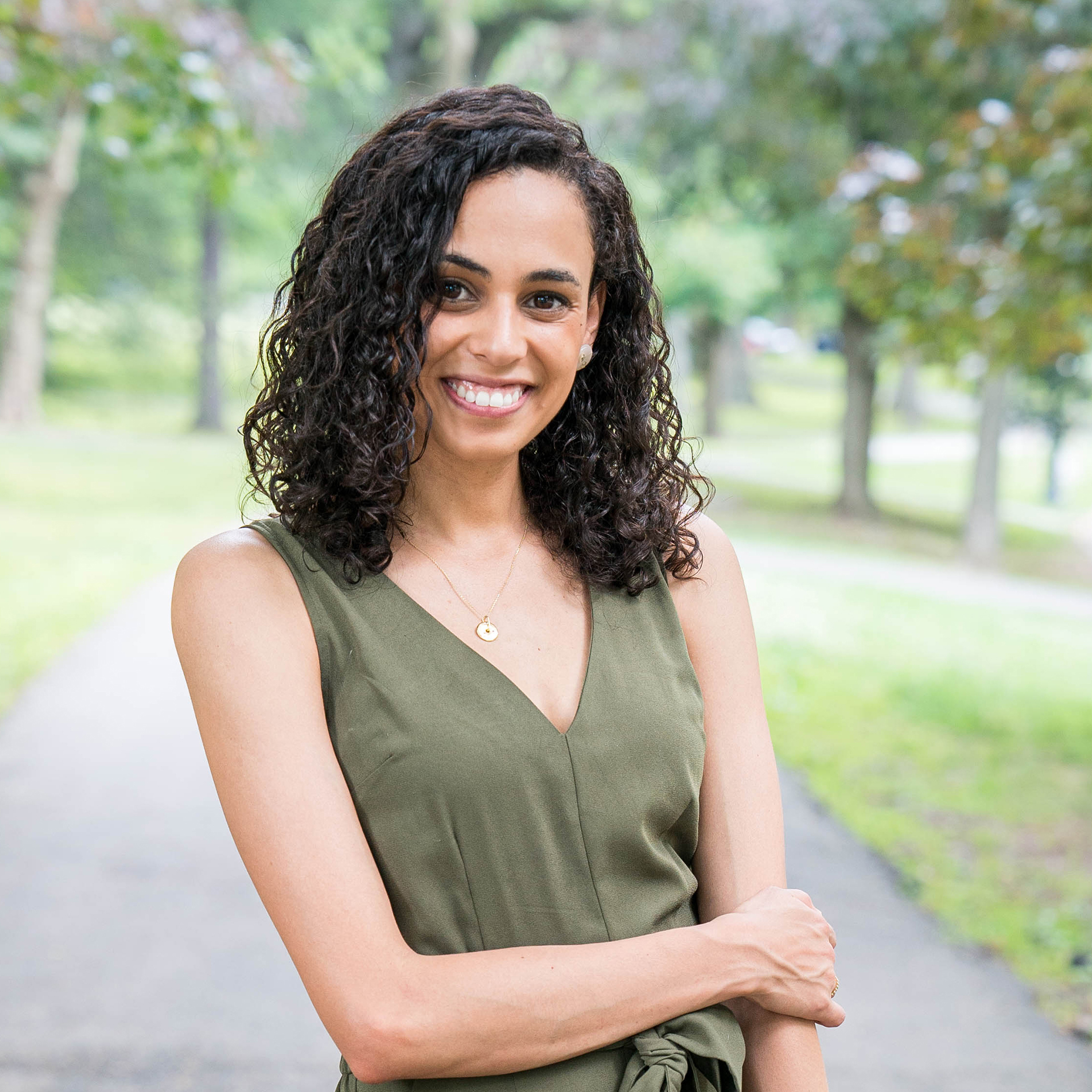 Christina Salgado, Assistant Dean of Diversity smiles at the camera on gray background