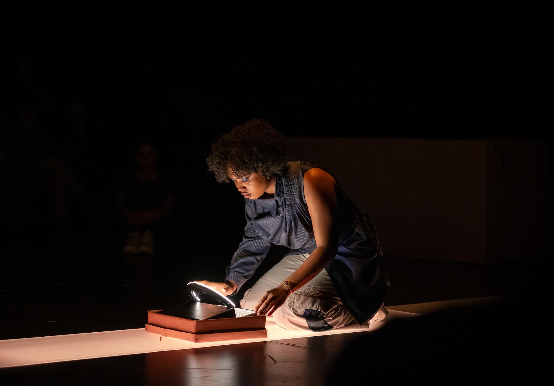 Actor crouching on the floor in front of a laptop prop