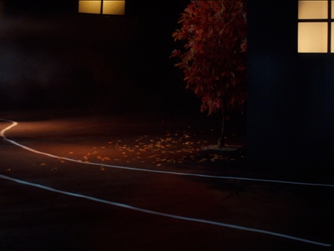 Film Still from Buckets. Image of a man and woman walking down a dark street. 