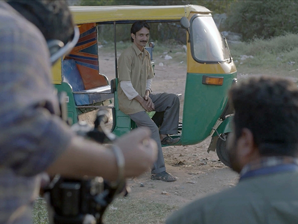 Film Still from Disco Obu. Image of man stepping out of vehicle.