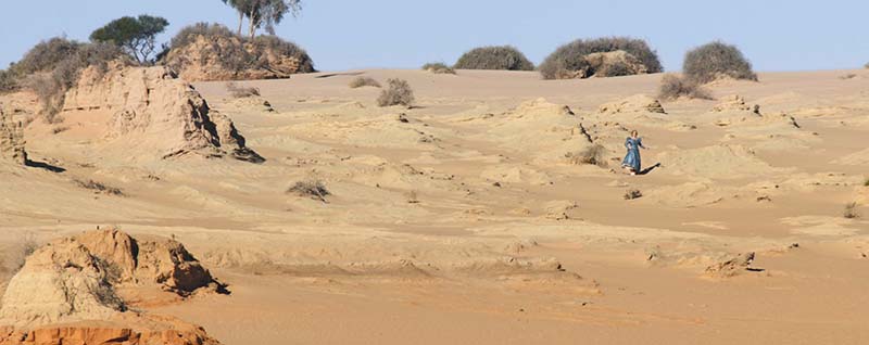 A woman running down a hillside.