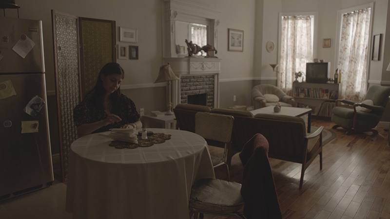 A young women sitting in her apartment.