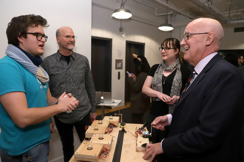 Andrew Hamilton talks with student about his project, also showing Dan O'Sullivan and Allison Parrish