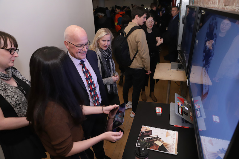 Andrew Hamilton talks with student about her project