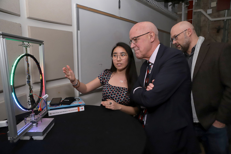 Student explains project to Andrew Hamilton