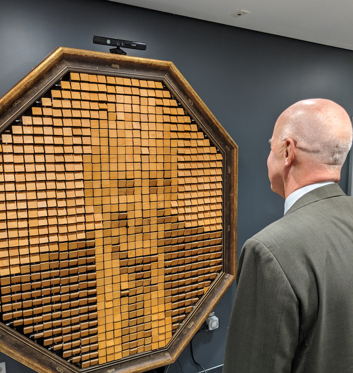 Andy Hamilton stands in front of the wooden mirror