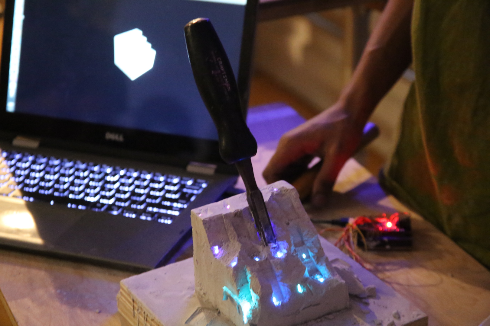 a screwdriver jammed into plaster embedded with LED's