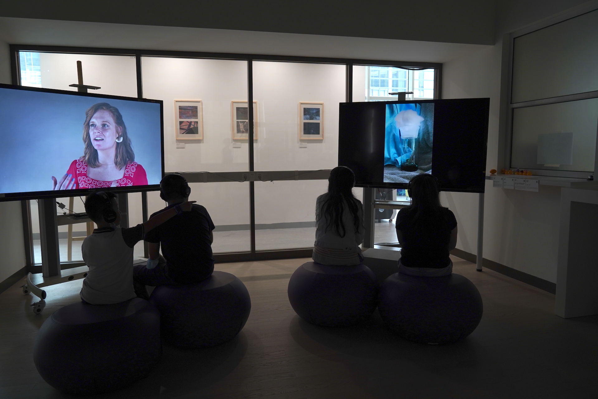 Two screens showing projects and people sitting in front of them