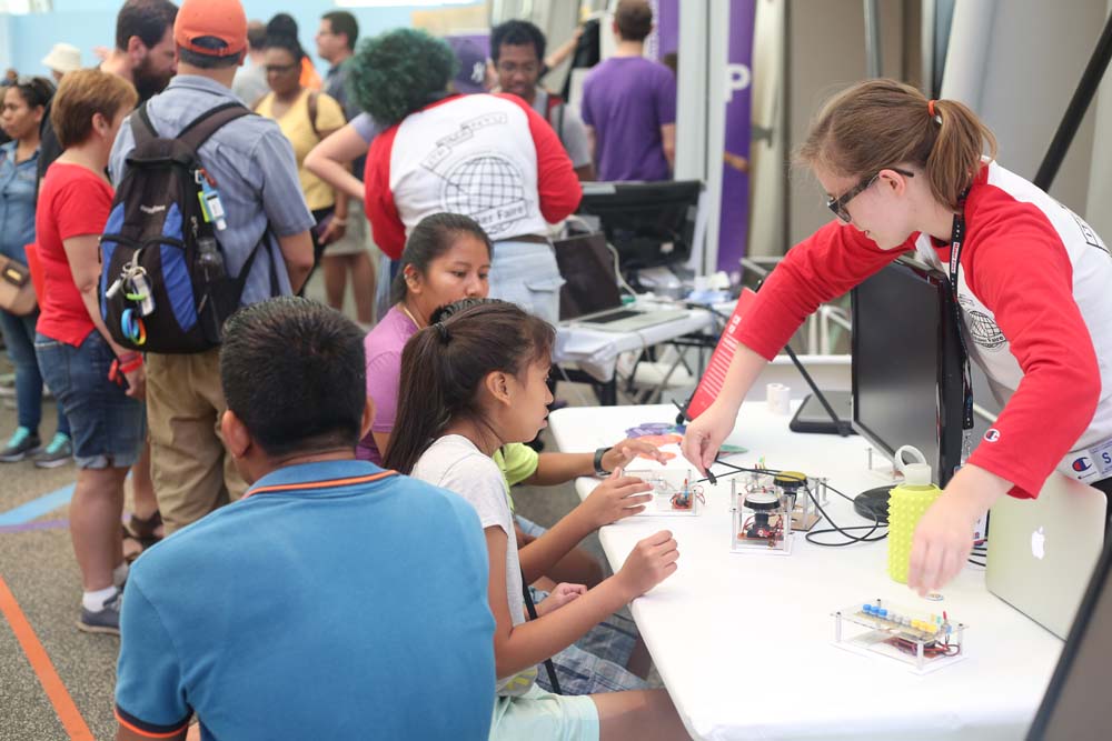 A woman demo'ing an audio project to young kids