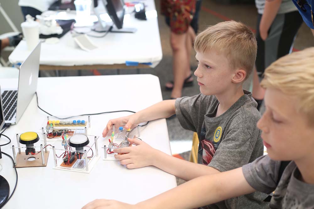 2 kids play with makeshift joysticks