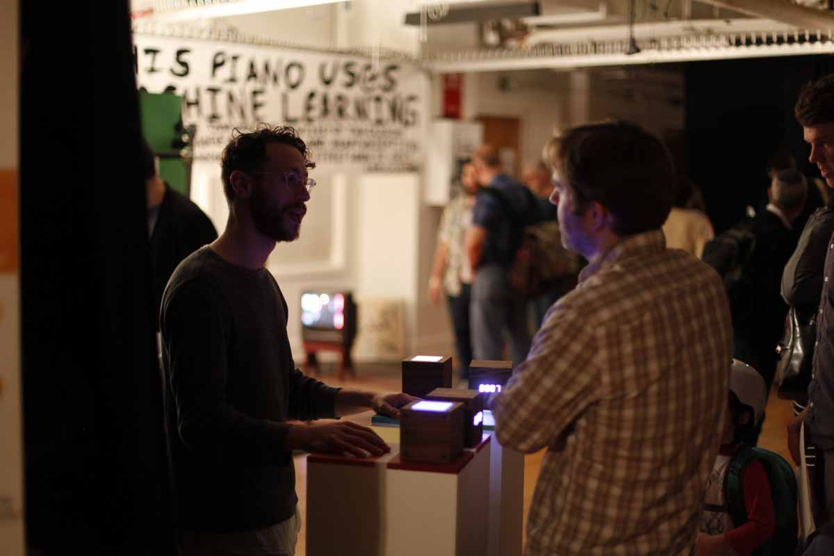 a student explaining his project of wooden light up cubes