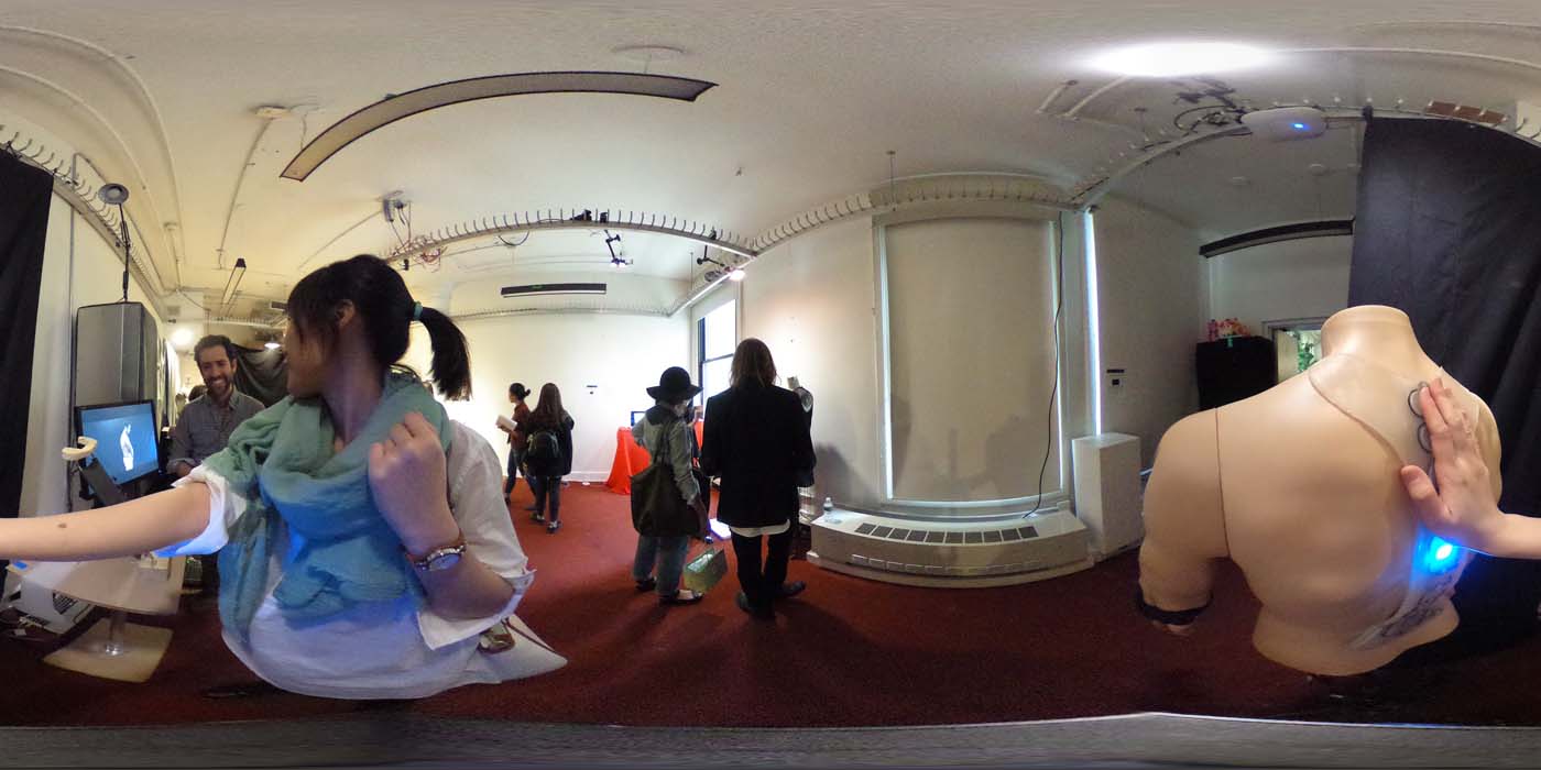 a 360 image of the hallway and people standing by projects at the show