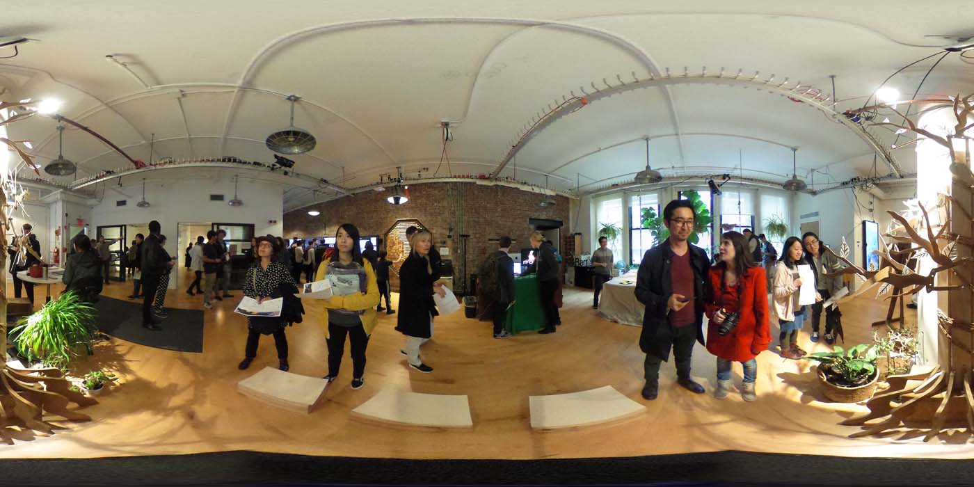 a 360 image of the hallway and people standing by projects at the show