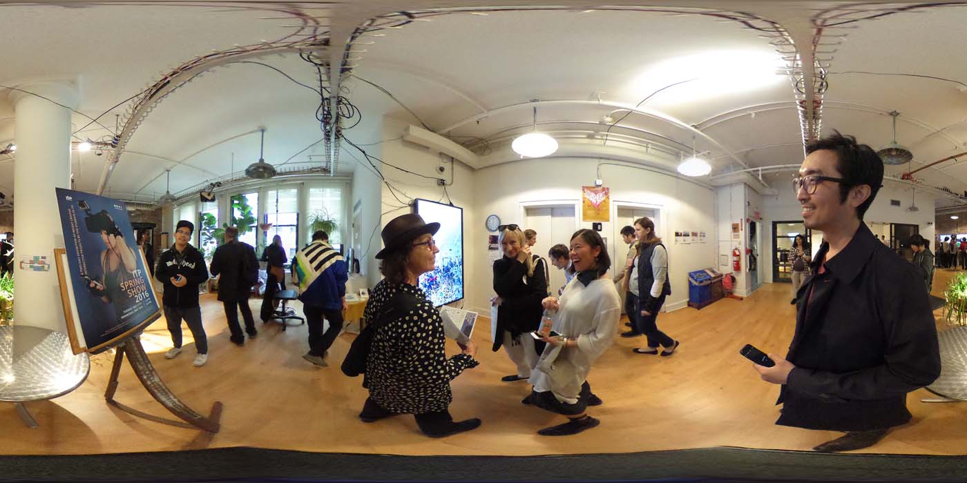 a 360 image of the hallway and people standing by projects at the show