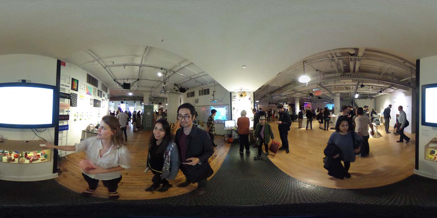 a 360 image of the hallway and people standing by projects at the show