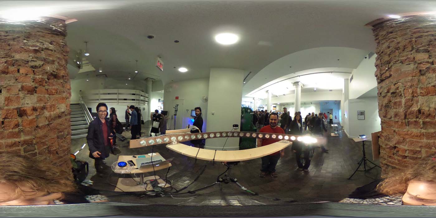 a 360 image of the hallway and people standing by projects at the show