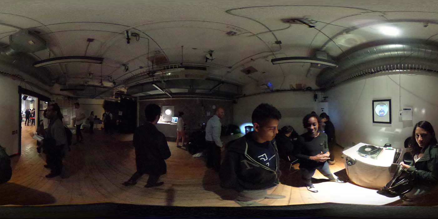 a 360 image of the hallway and people standing by projects at the show