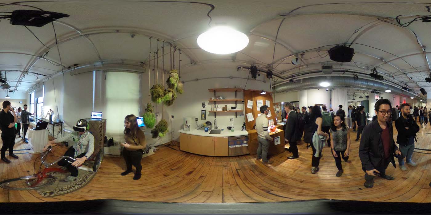 a 360 image of the hallway and people standing by projects at the show