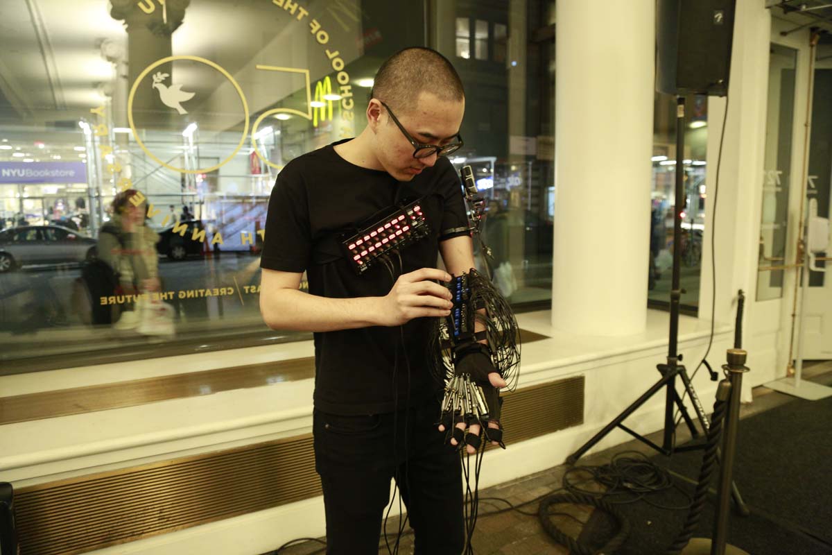 A man with a glove that is heavily wired and makes music