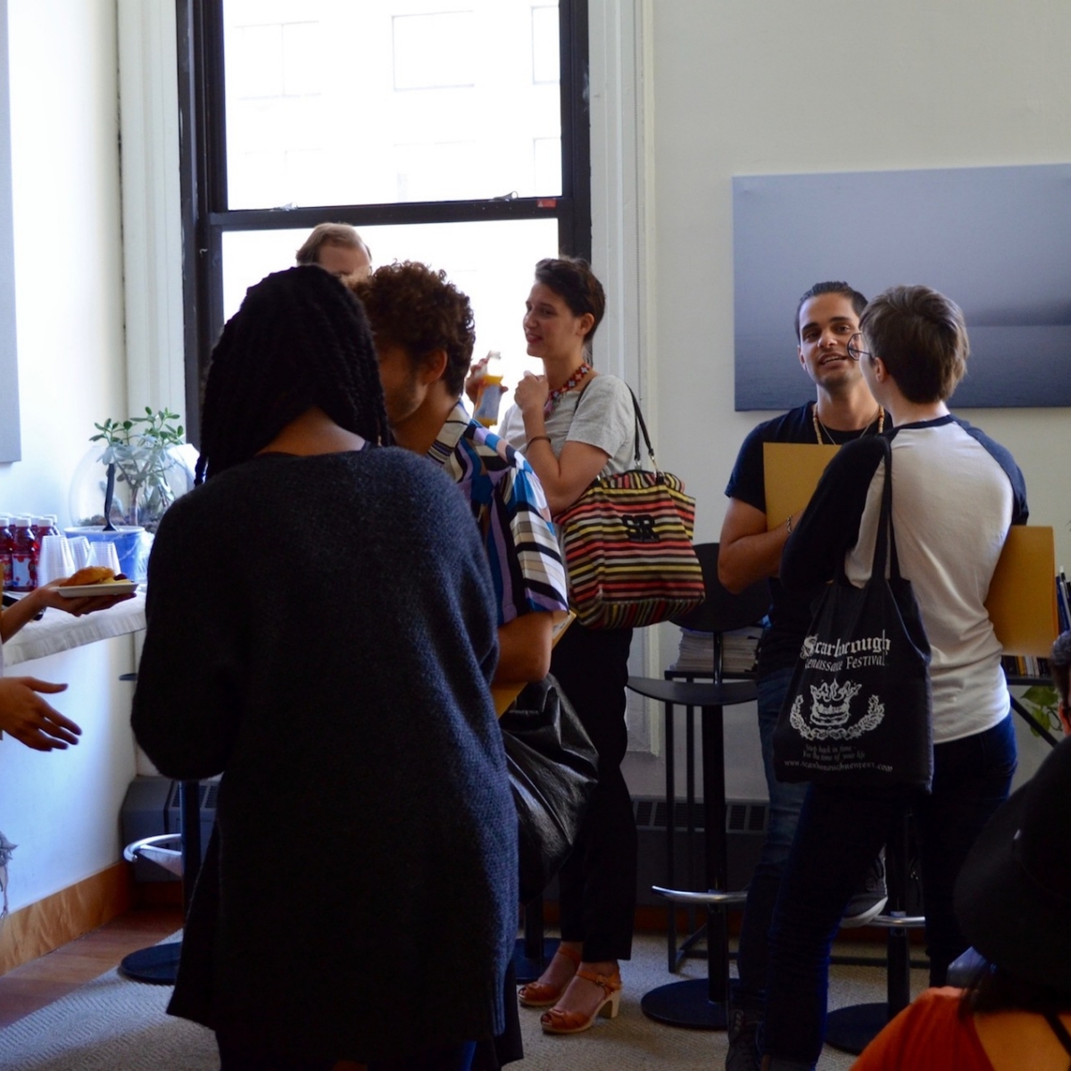 Students and faculty gathered together in a classroom conversing while eating lunch