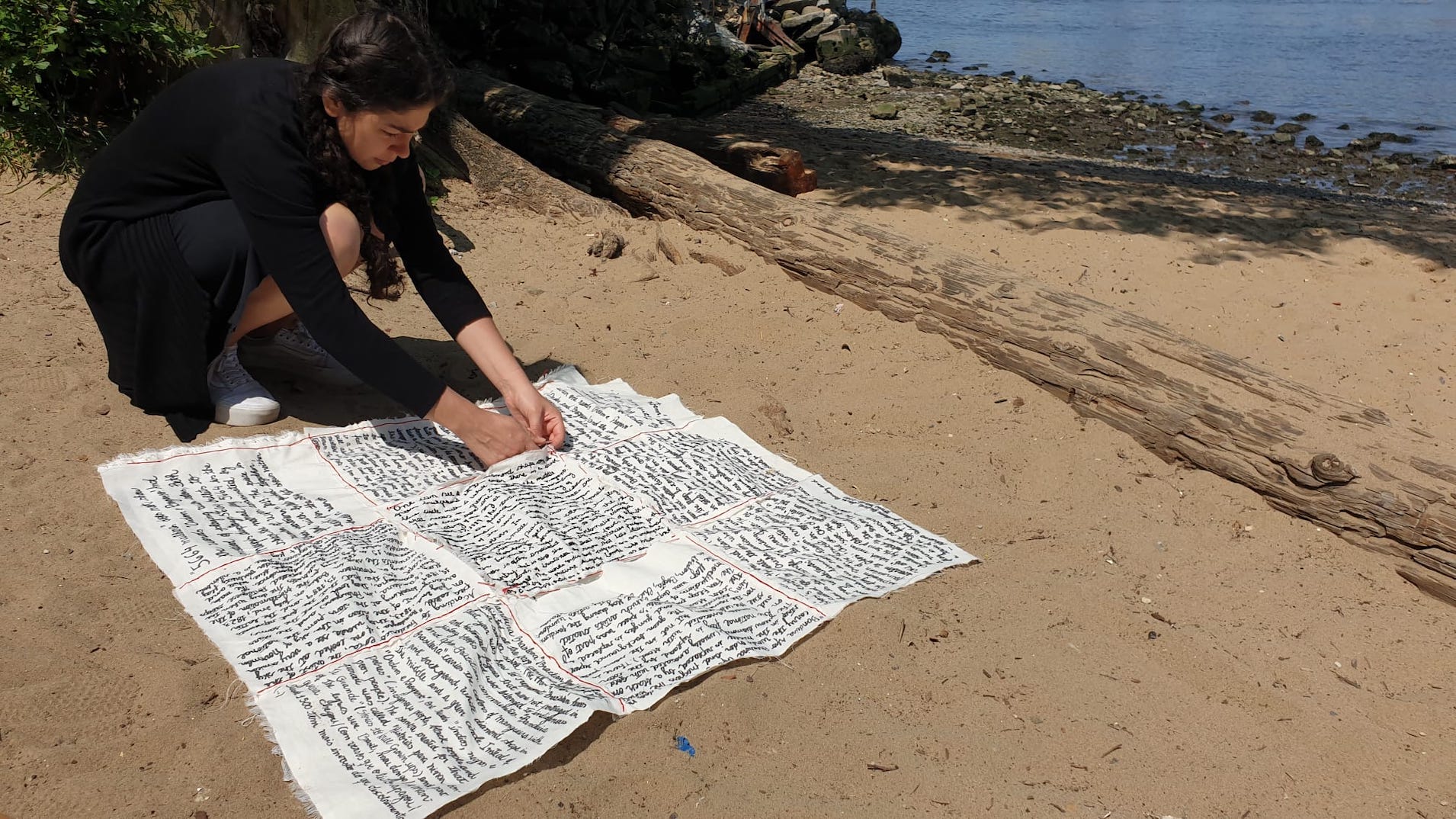 Woman bending down writing on paper