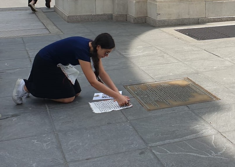 Woman bending over writing on paper