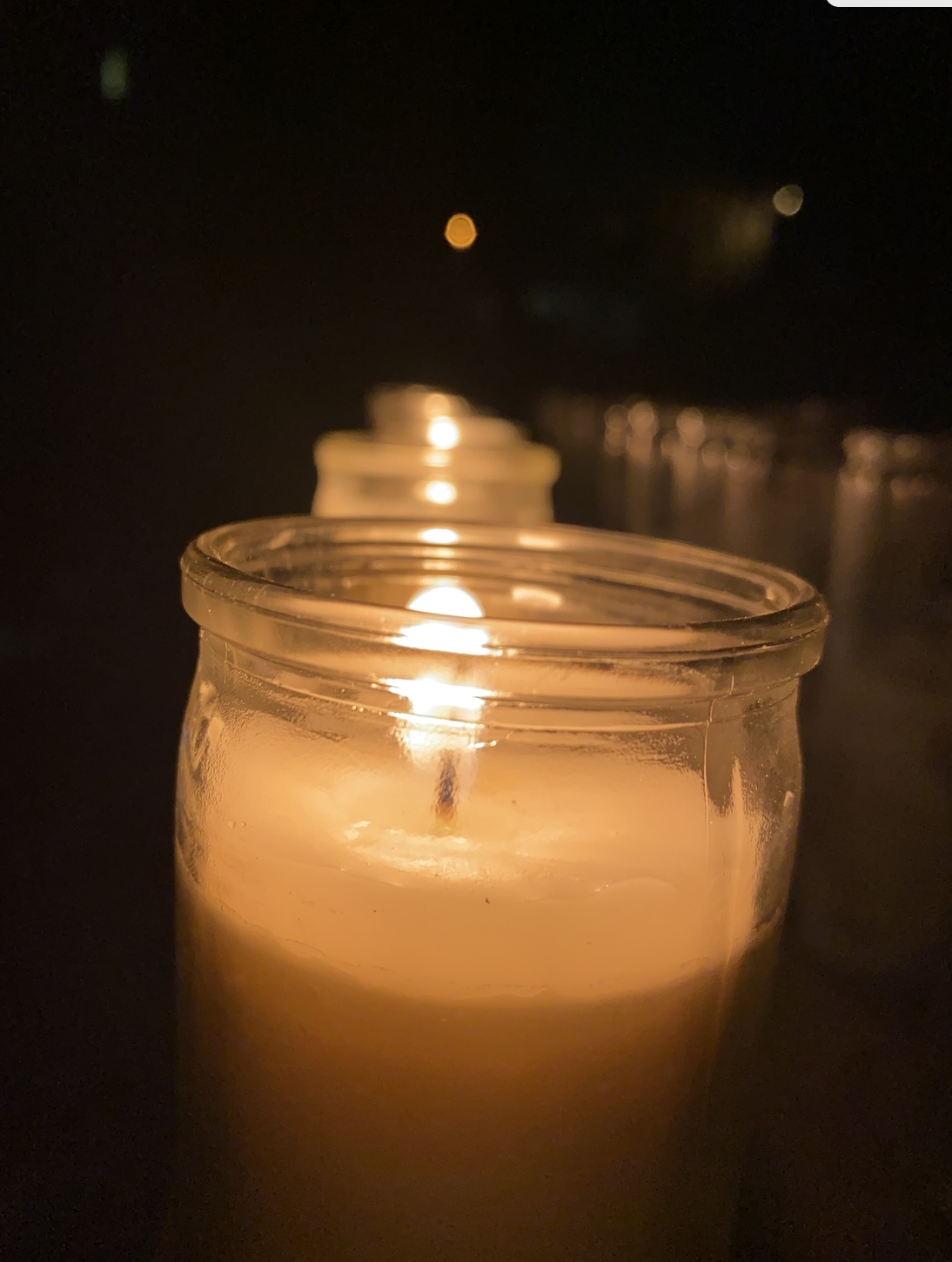 prayer candles being lit one by one