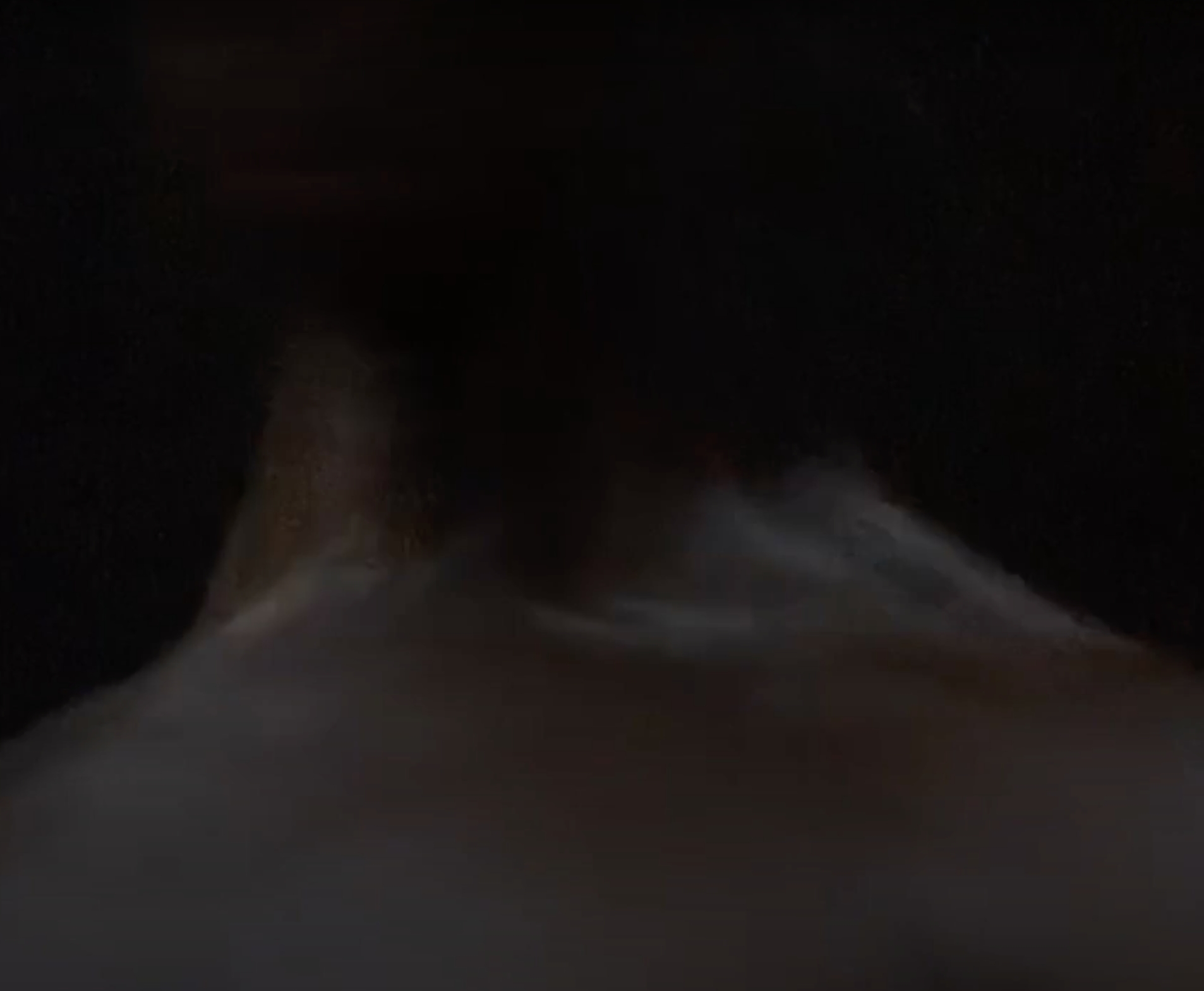 A close-cropped widescreen digital video image of the neck and shoulders of person seen from behind, slightly blurring and repeating against a black background