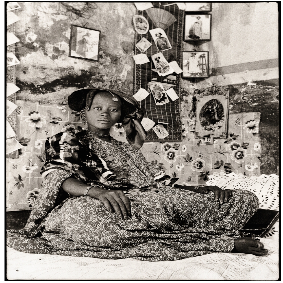 .Black and white image of an african girl next to photographs