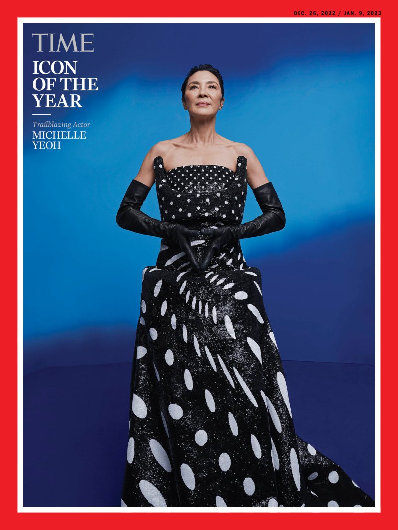 Image of a Michelle Yeoh against a blue background with a red border