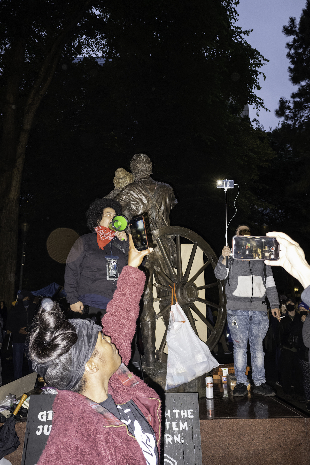 photograph of a protest scene with cell phone cameras documenting protesting