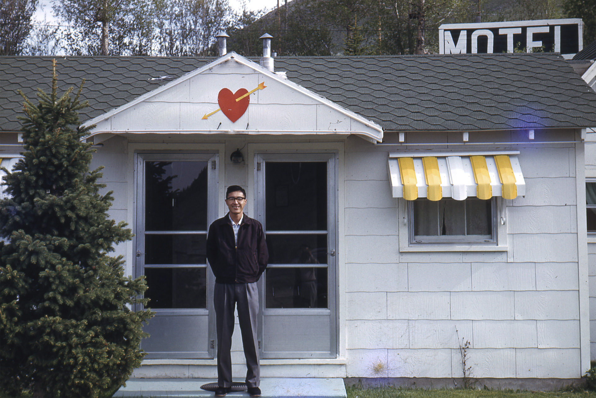 outdoor portrait of a person standing in front of doors to a house