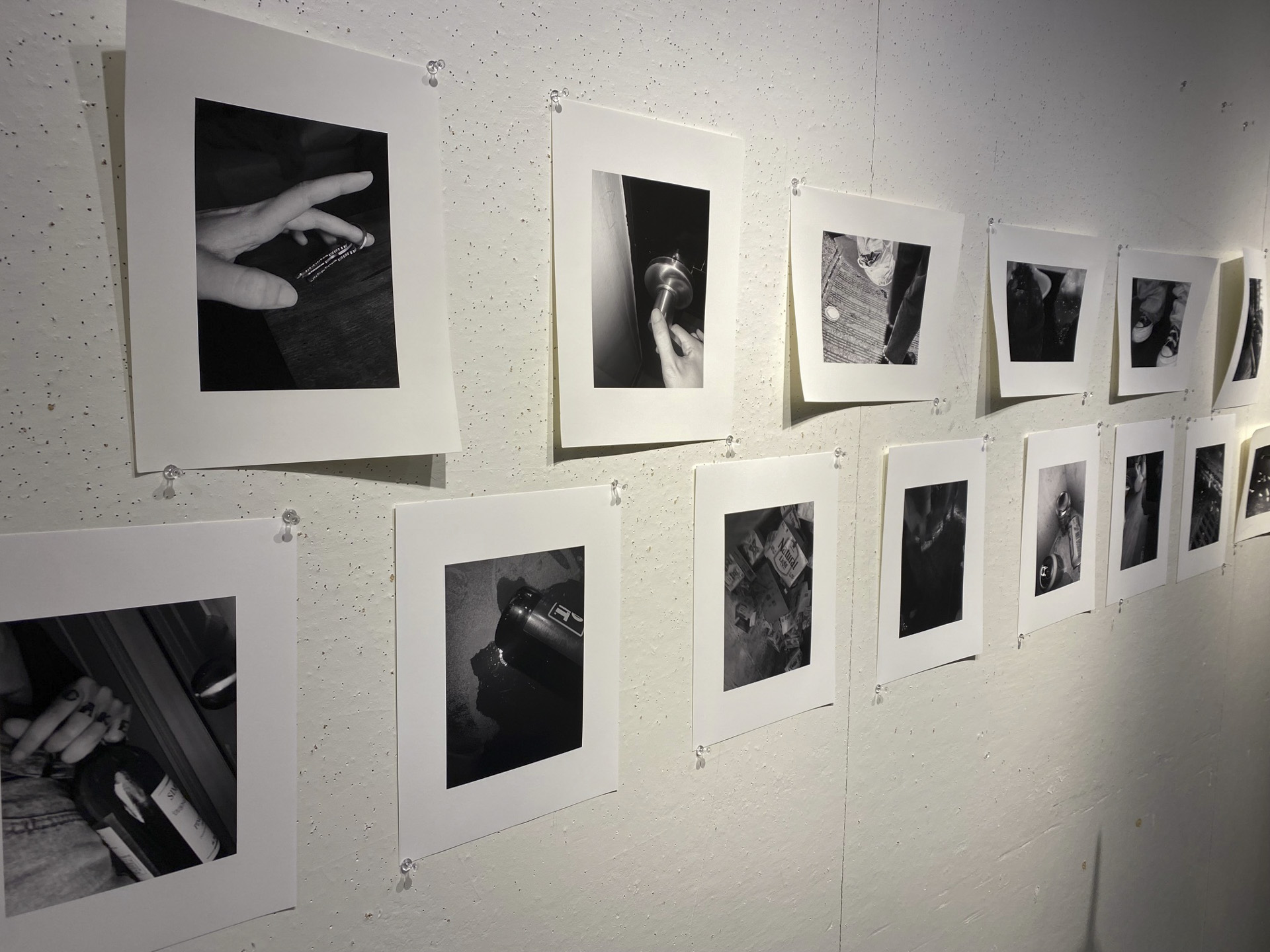 a student poses with their work presentation on wall