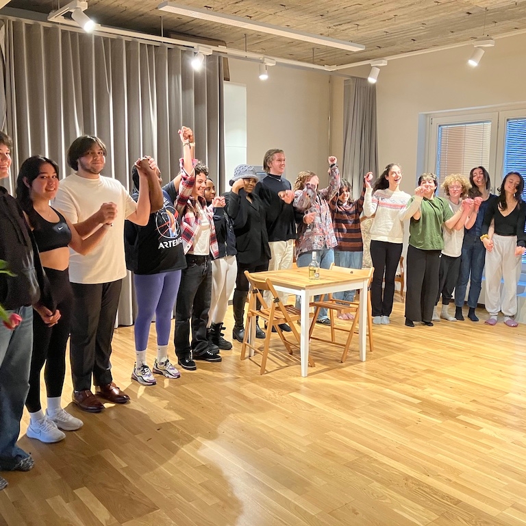 Spring 2023 Stanislavski, Brecht, and Beyond students holding hands in a curtain call bow at the end of a presentation