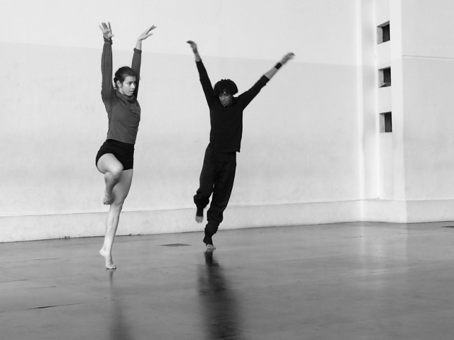 Black and white photo of two dancers in a studio.